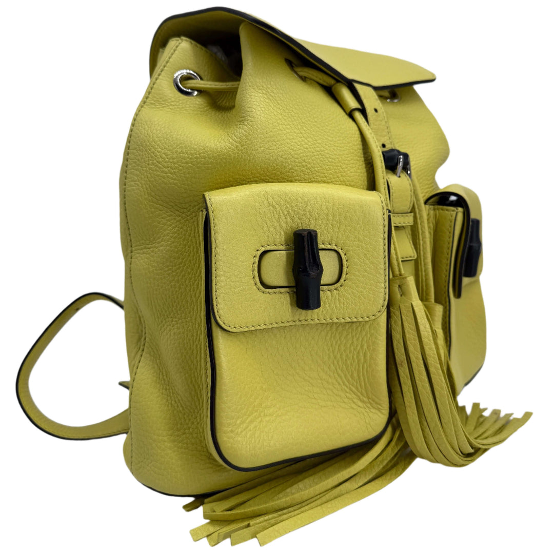Gucci Medium Bamboo Backpack in vibrant mimosa yellow calfskin with fringe and structured design.