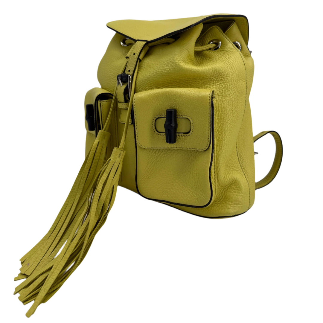 Gucci Cellarius Medium Bamboo Backpack in vibrant mimosa flower yellow with fringe detailing and top handle.