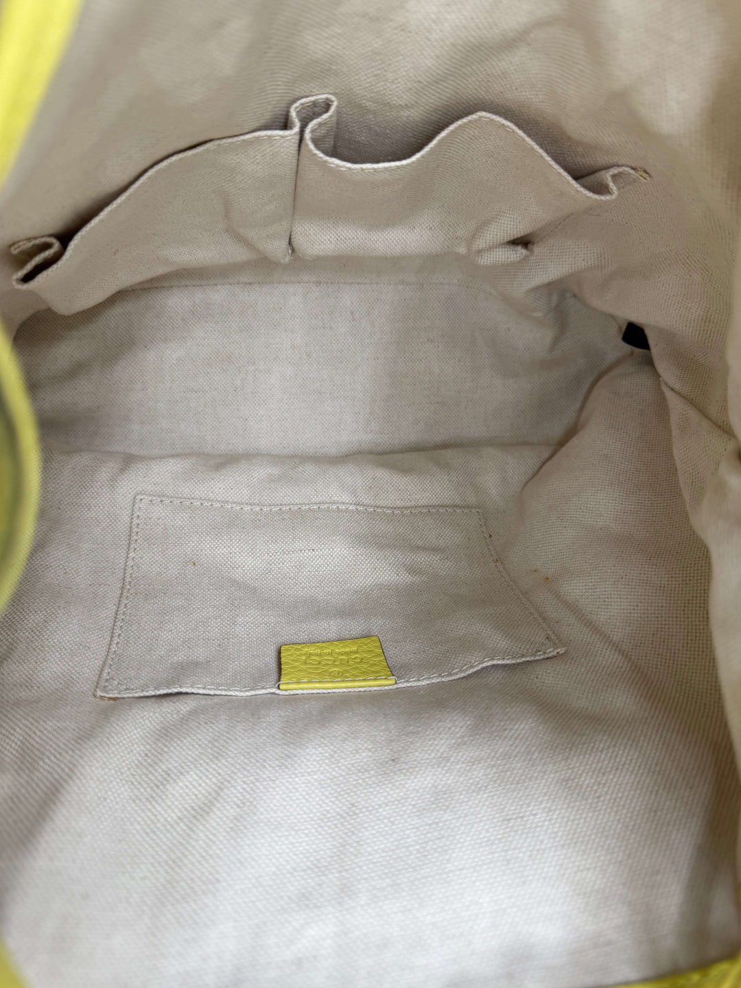 Interior view of Gucci Cellarius Medium Bamboo Backpack in Mimosa Flower, showcasing soft fabric lining and pocket.