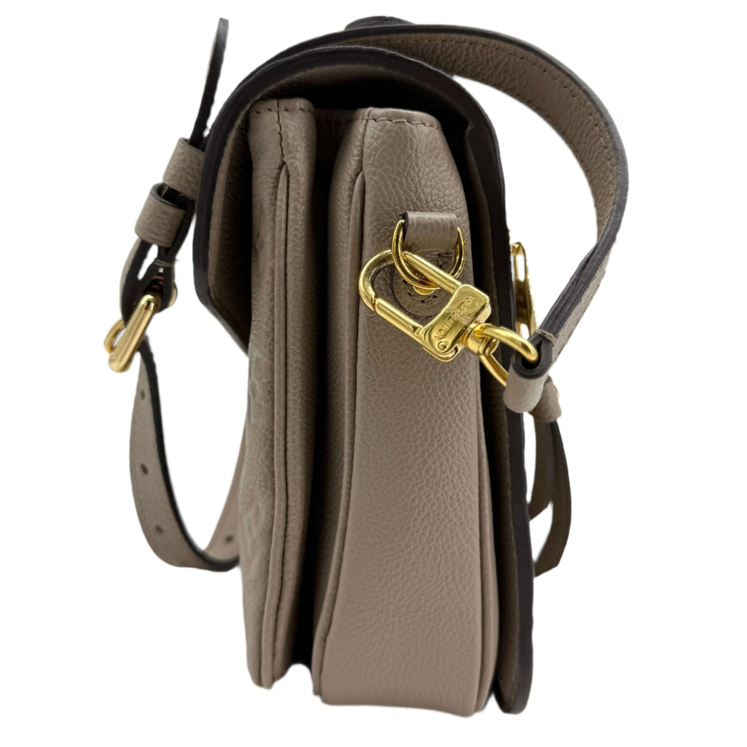 Side view of Louis Vuitton Pochette Métis in Tourterelle Grey with gold-tone hardware and leather strap.