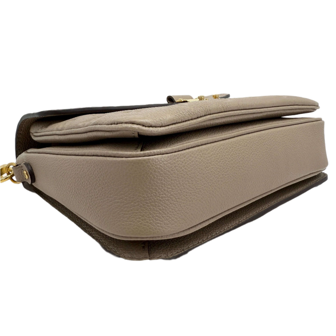 Side view of Louis Vuitton Pochette Métis in Tourterelle Grey Monogram Empreinte Leather showcasing its elegant silhouette.