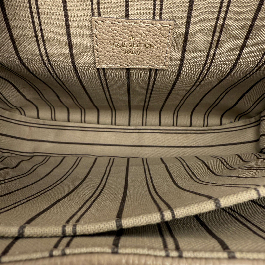 Interior of Louis Vuitton Pochette Métis showcasing striped lining and embossed logo detail.