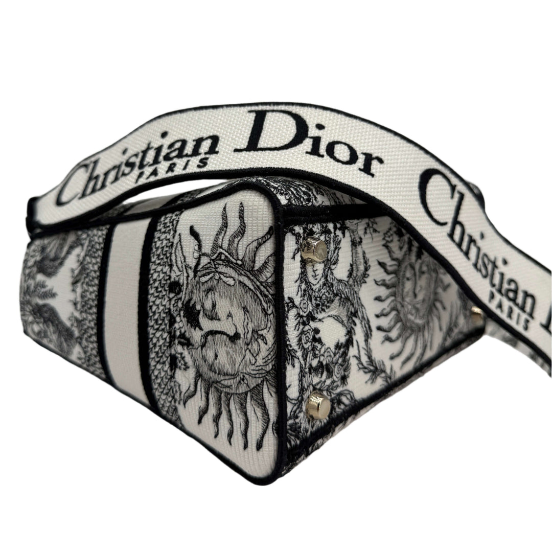 Christian Dior medium bag with intricate black and white design and logo strap, showcasing luxury and elegance.