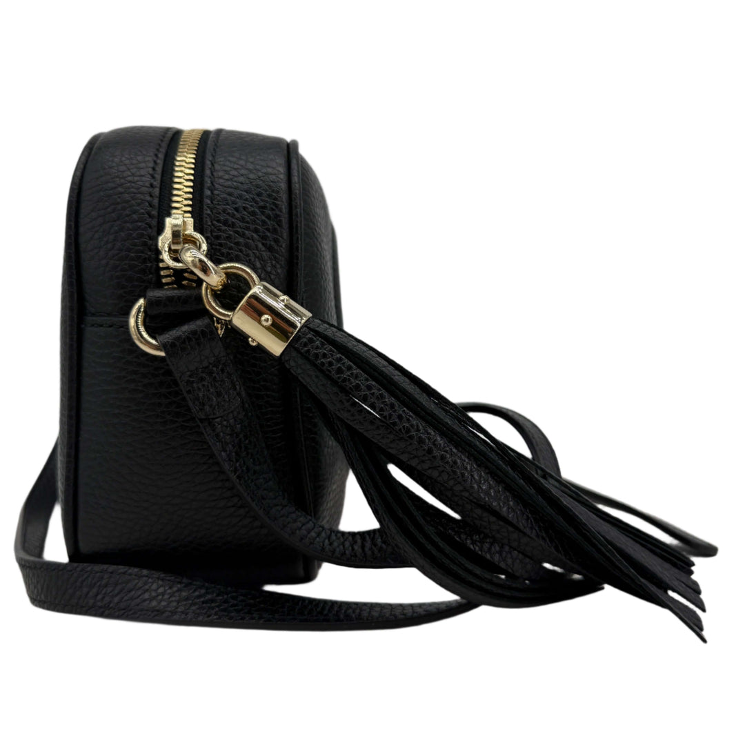 Side view of the Gucci Small Soho Disco Bag in black pebbled calfskin leather featuring a gold tassel and zip closure.