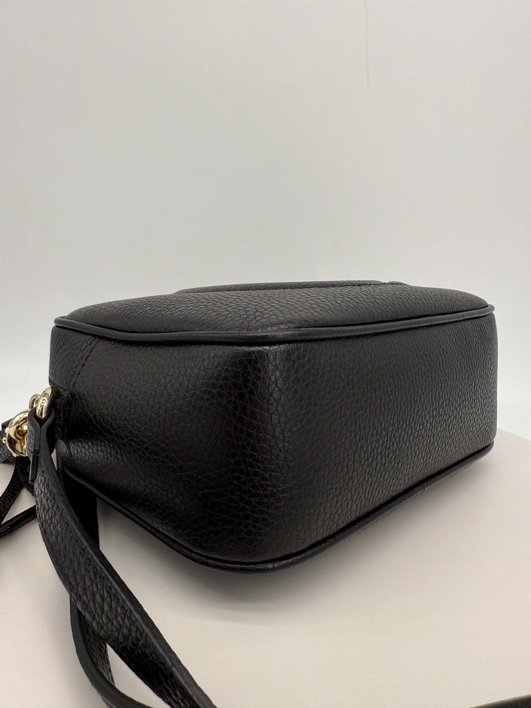 Gucci Small Soho Disco Bag side view showcasing black pebbled calfskin leather and sleek design.