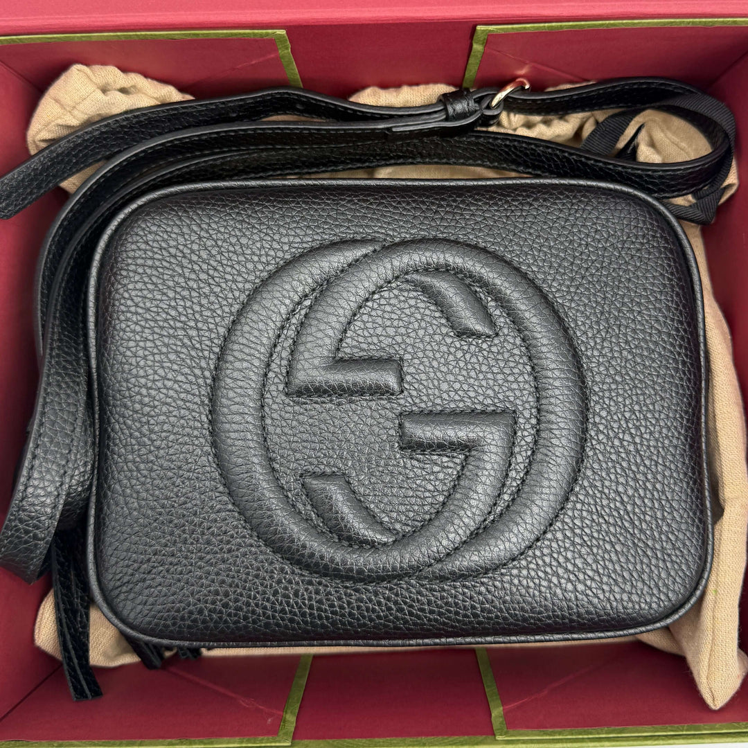 Gucci Small Soho Disco Bag in black pebbled calfskin leather with iconic interlocking G logo and gold tassel.
