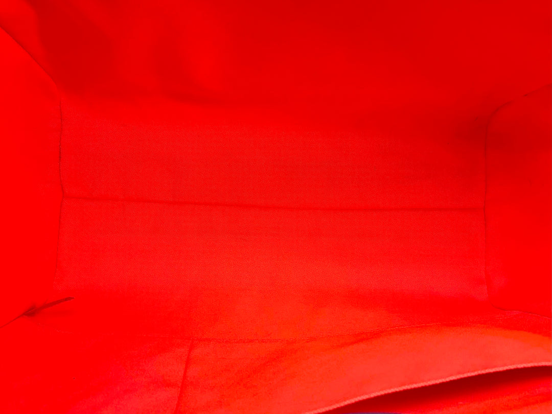 Interior view of a vibrant red tote bag, showcasing its spacious, unembellished fabric lining.