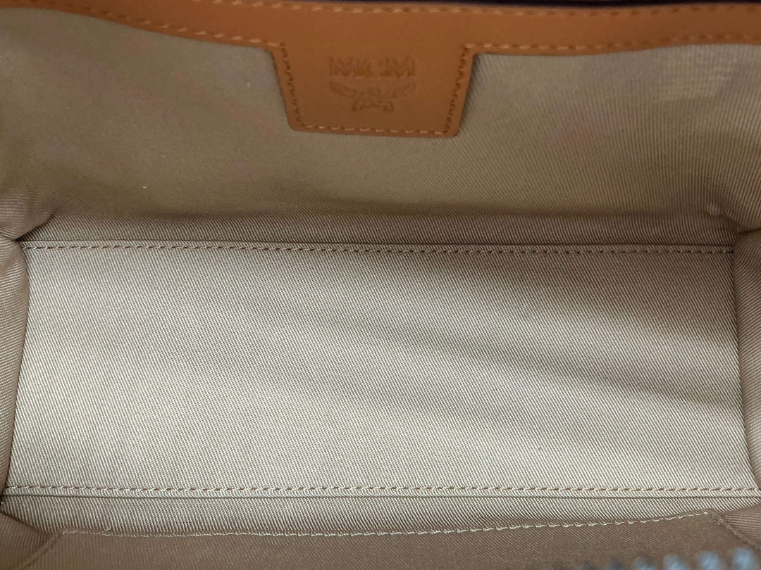 Interior view of Fendi Zucca Mini Baguette featuring beige lining and leather tag, showcasing spacious design.