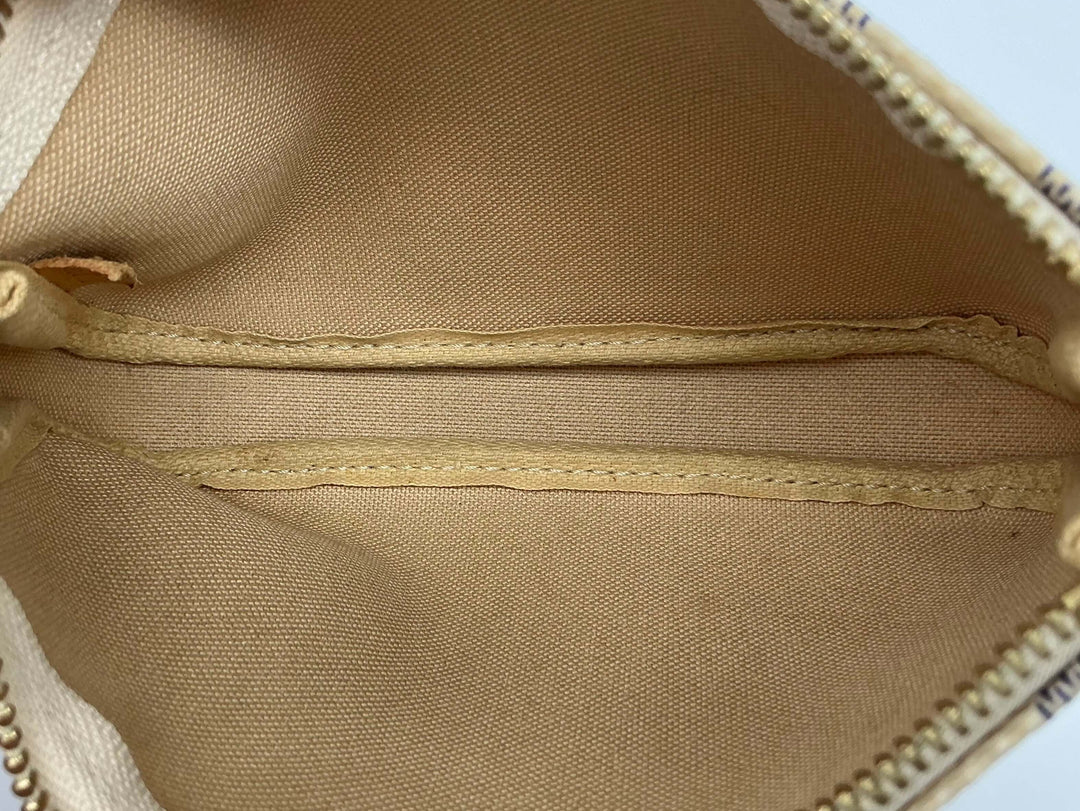 Interior view of the Louis Vuitton Damier Azur Mini Pochette Accessories showing tan lining and organizational pockets.