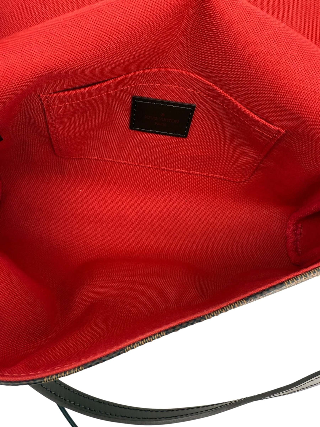 Interior view of the Louis Vuitton Damier Ebene Favorite MM Bag | LuxLoveLouis showcasing its vibrant red lining and pocket detail.