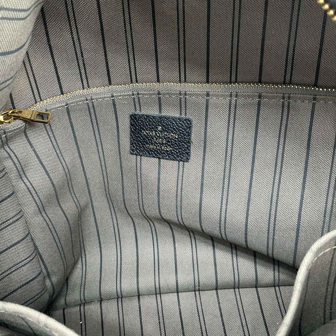 Interior view of Louis Vuitton Sorbonne Backpack showcasing striped lining and zipped pocket detail.