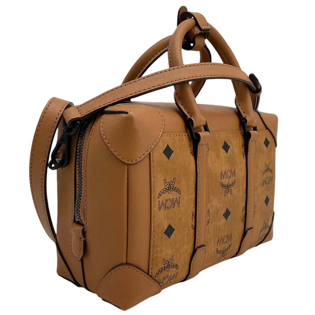 MCM Mini Satchel in tan leather with signature logo, featuring dual handles and adjustable shoulder strap for versatile styling.