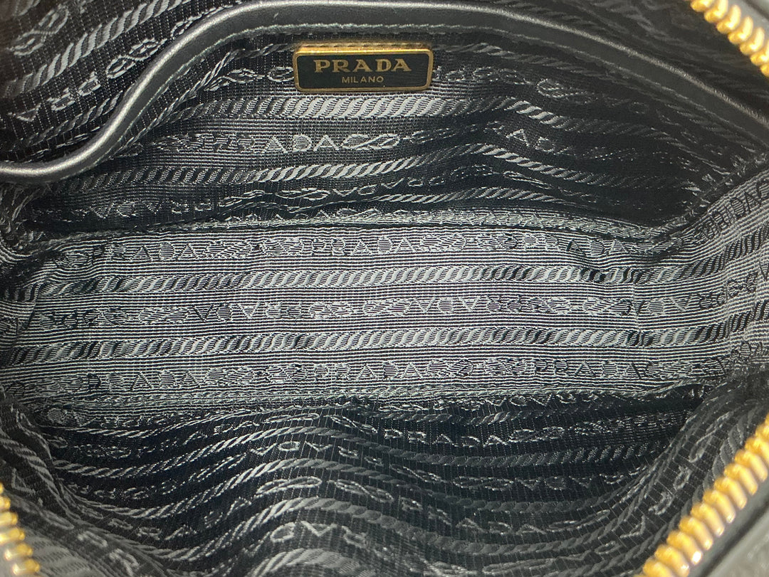 Interior view of the Prada Nappa Gaufre Camera Bag, featuring luxurious black lining with the Prada logo.