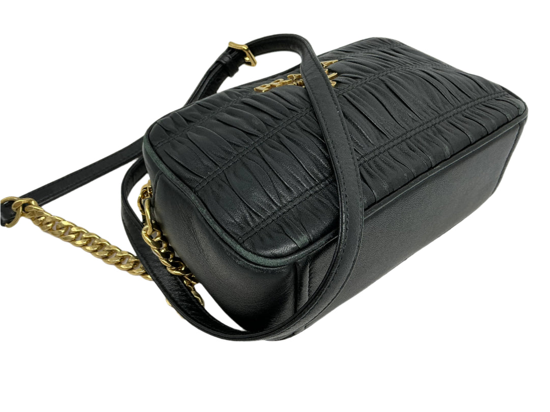 Prada Nappa Gaufre camera bag in black pleated lambskin leather with a gold-tone chain strap.