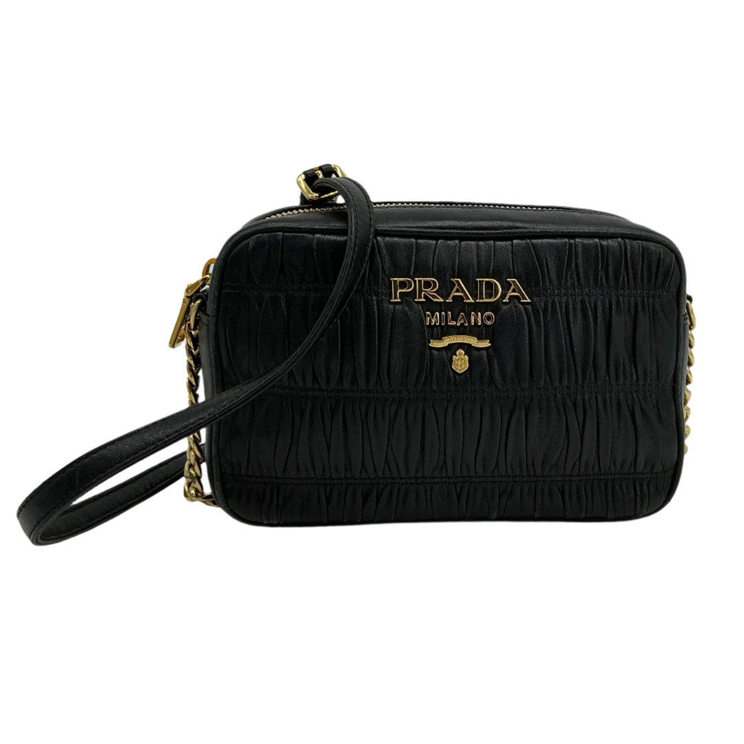Prada Nappa Gaufre Camera Bag in black pleated lambskin leather with gold-tone logo and adjustable chain strap.