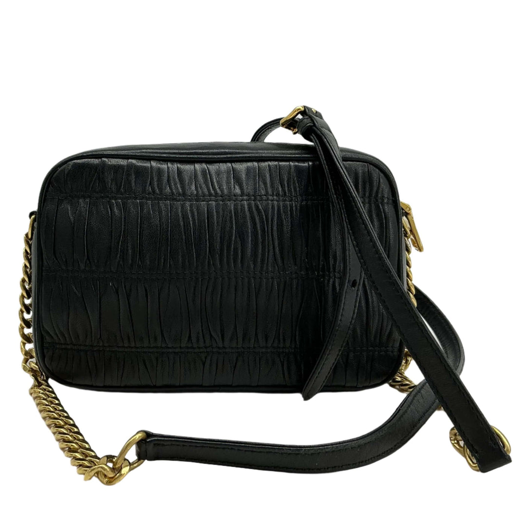 Prada Nappa Gaufre Camera Bag in black pleated lambskin leather with gold-tone chain strap and leather shoulder pad.