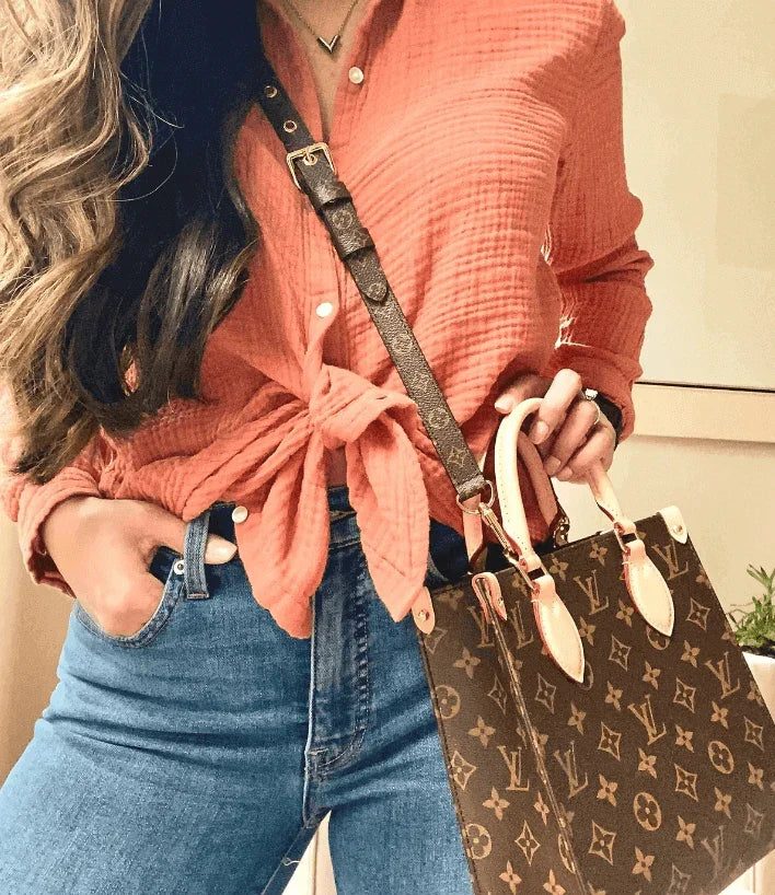 Why Invest in Pre-Owned Luxury Handbags? Stylish individual showcasing a Louis Vuitton bag with casual attire.