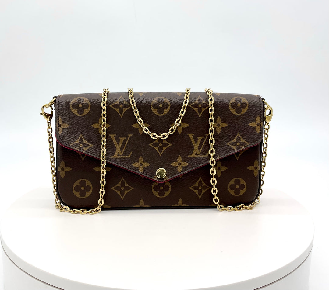 LOUIS VUITTON Monogram Felicie Pochette with chain strap displayed on a white pedestal, showcasing its signature design.
