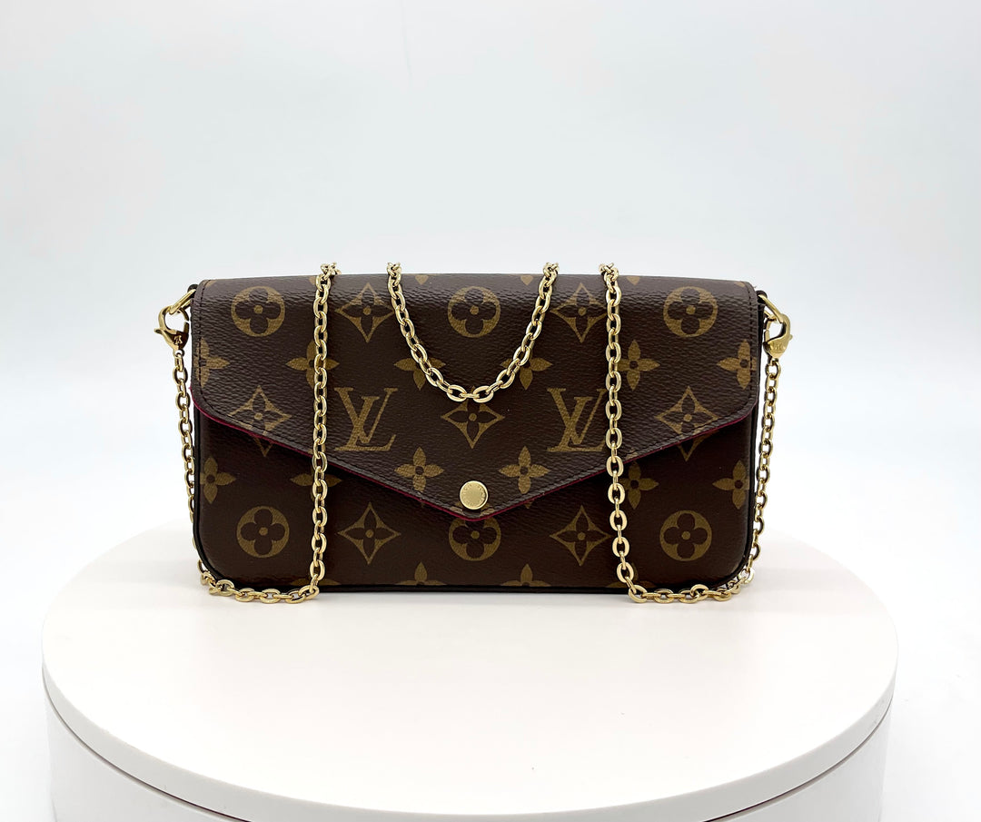 LOUIS VUITTON Monogram Felicie Pochette with chain strap displayed on a white podium.