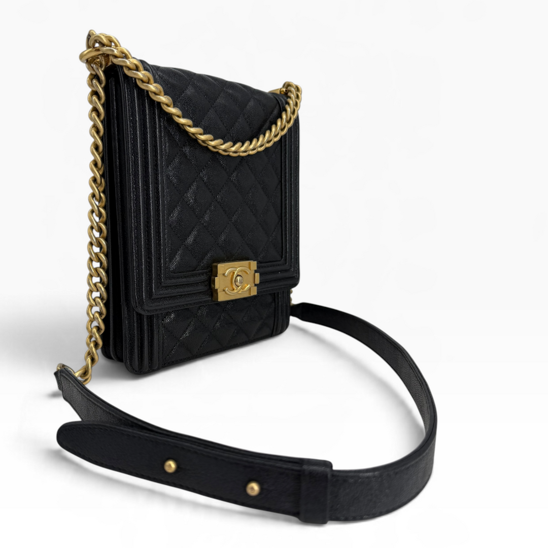 Chanel North South Boy Flap Bag angled front with black caviar leather, aged gold CC clasp and adjustable strap