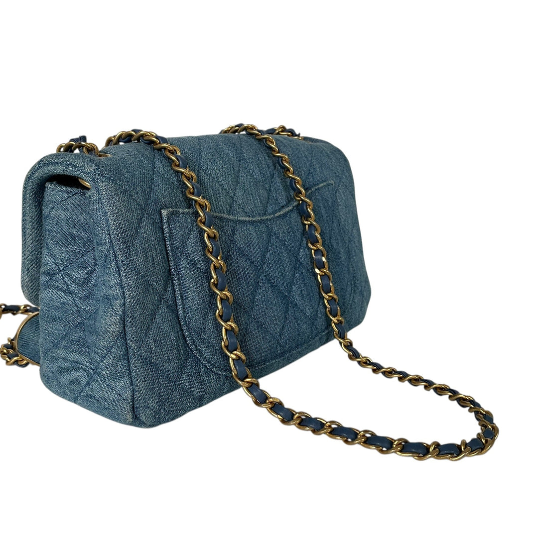 A blue quilted leather shoulder bag with a gold chain strap, shown on a plain white background.