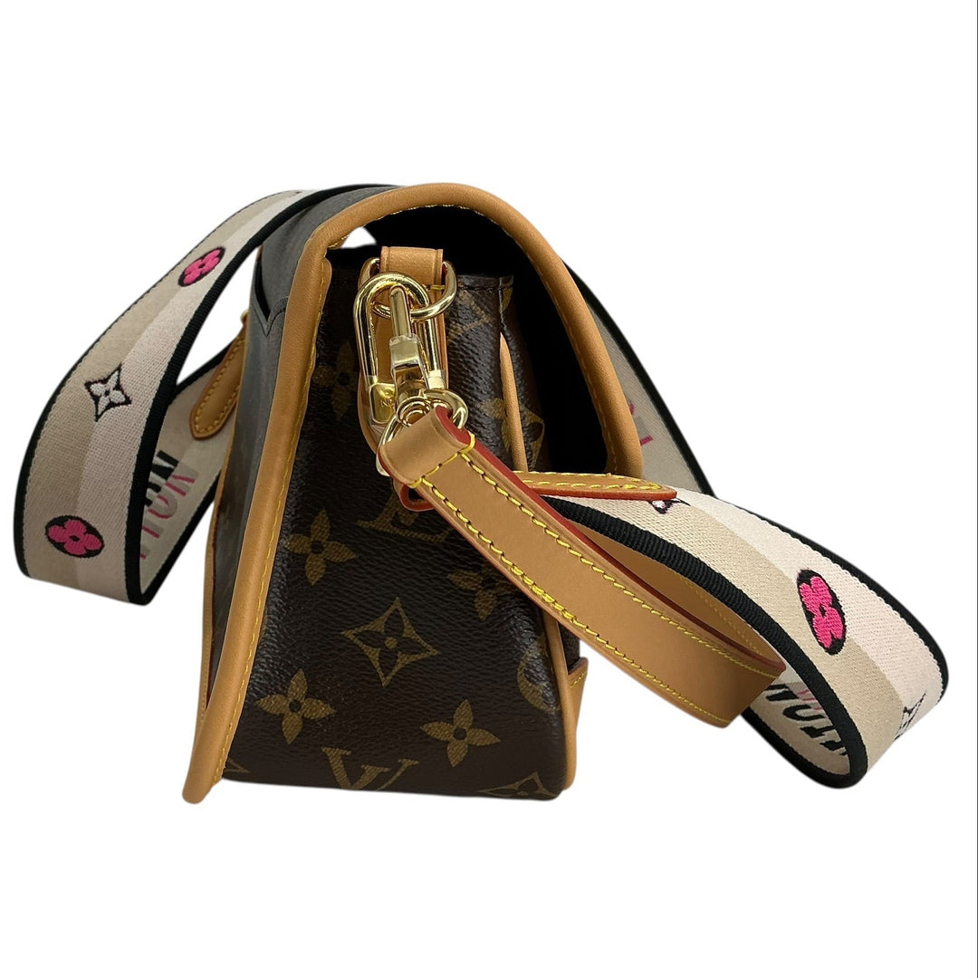 Louis Vuitton monogram canvas shoulder bag with a tan leather strap and a wide beige patterned shoulder strap featuring pink smiley faces and gold LV monogram motifs, shown on a white background.