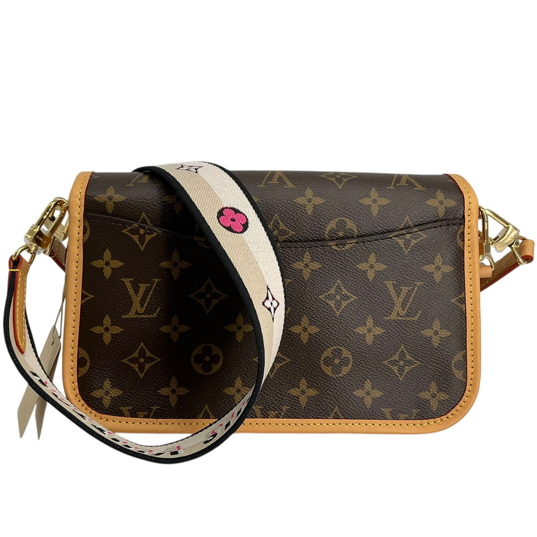 Louis Vuitton monogram canvas shoulder bag with a tan leather trim and a white monogram web belt featuring a pink crystal accent, shown on a white background.