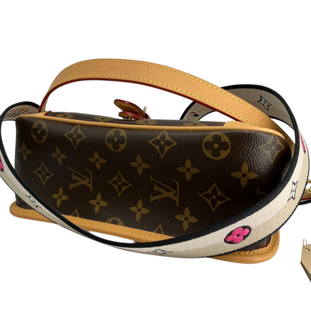 Louis Vuitton monogram canvas shoulder bag with a tan leather handle and a wide white shoulder strap featuring pink floral accents and black trim, shown on a white background.
