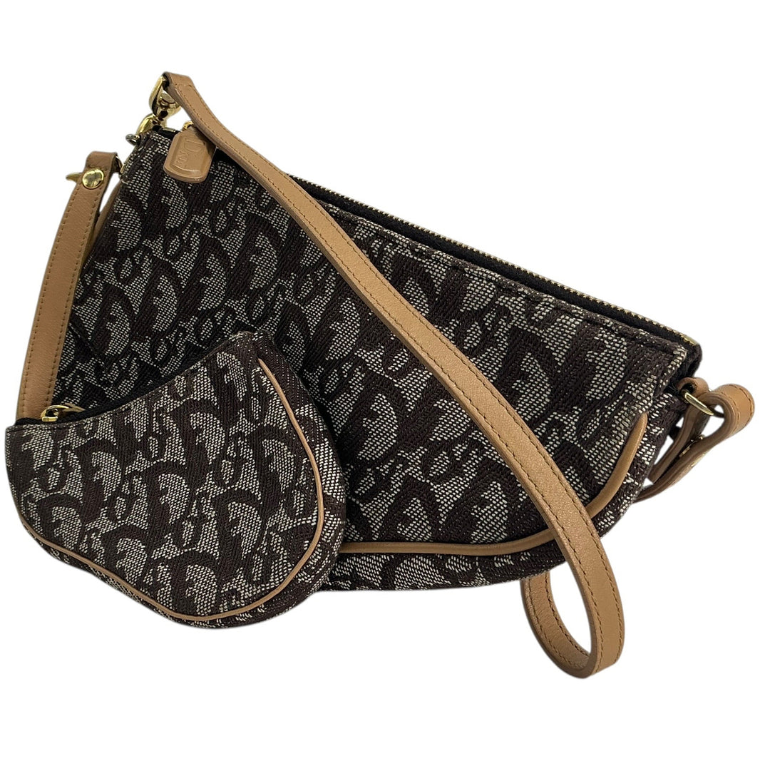 A black and gray monogram patterned crossbody handbag with tan leather trim and strap, shown on a plain white background.