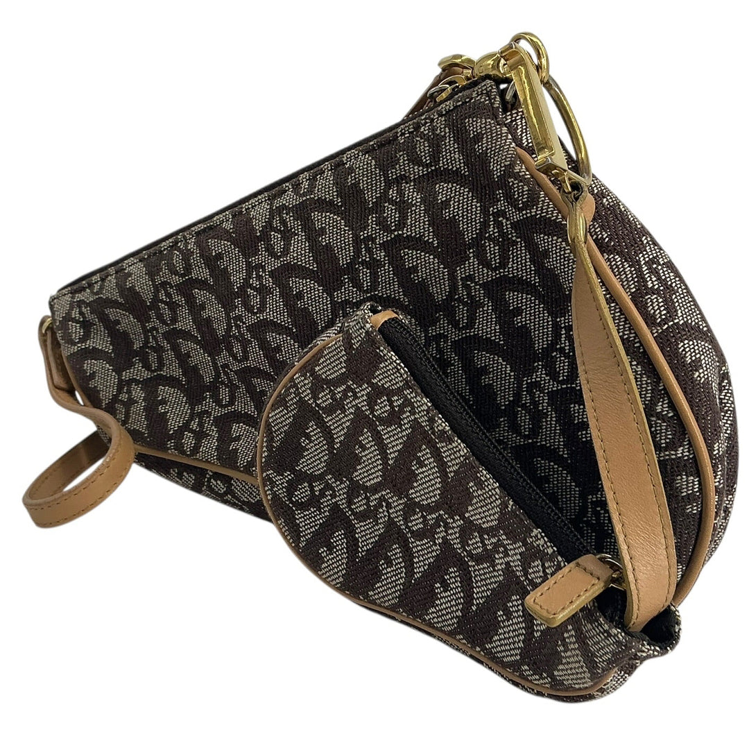 A Dior monogram shoulder bag in black and brown coated canvas with tan leather trim and gold-tone hardware, shown on a plain white background.