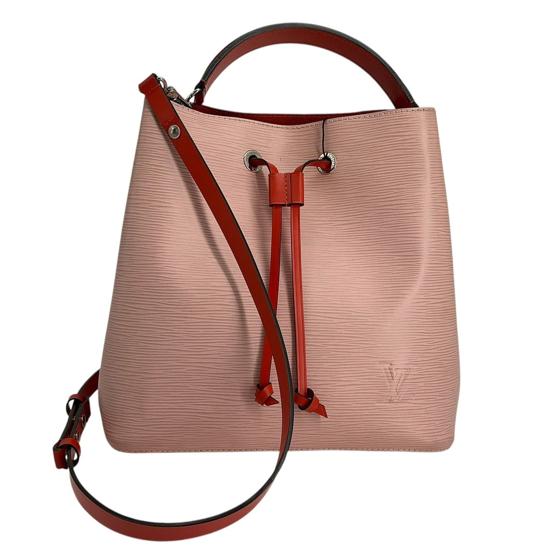 A light pink textured leather bucket bag with dark red leather handles, drawstring, and shoulder strap, featuring a subtle embossed LV logo on the bottom right.