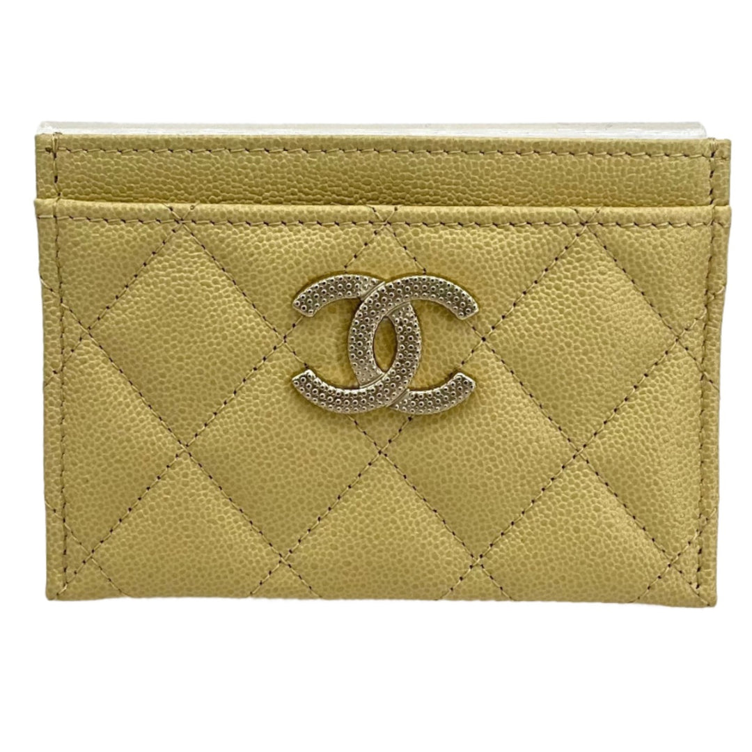 CHANEL yellow card holder with quilted design and iconic CC logo.