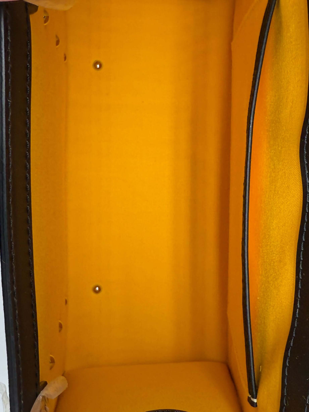 Interior view of Goyard Goyardine Saigon PM handbag showcasing bright yellow lining and structured design.