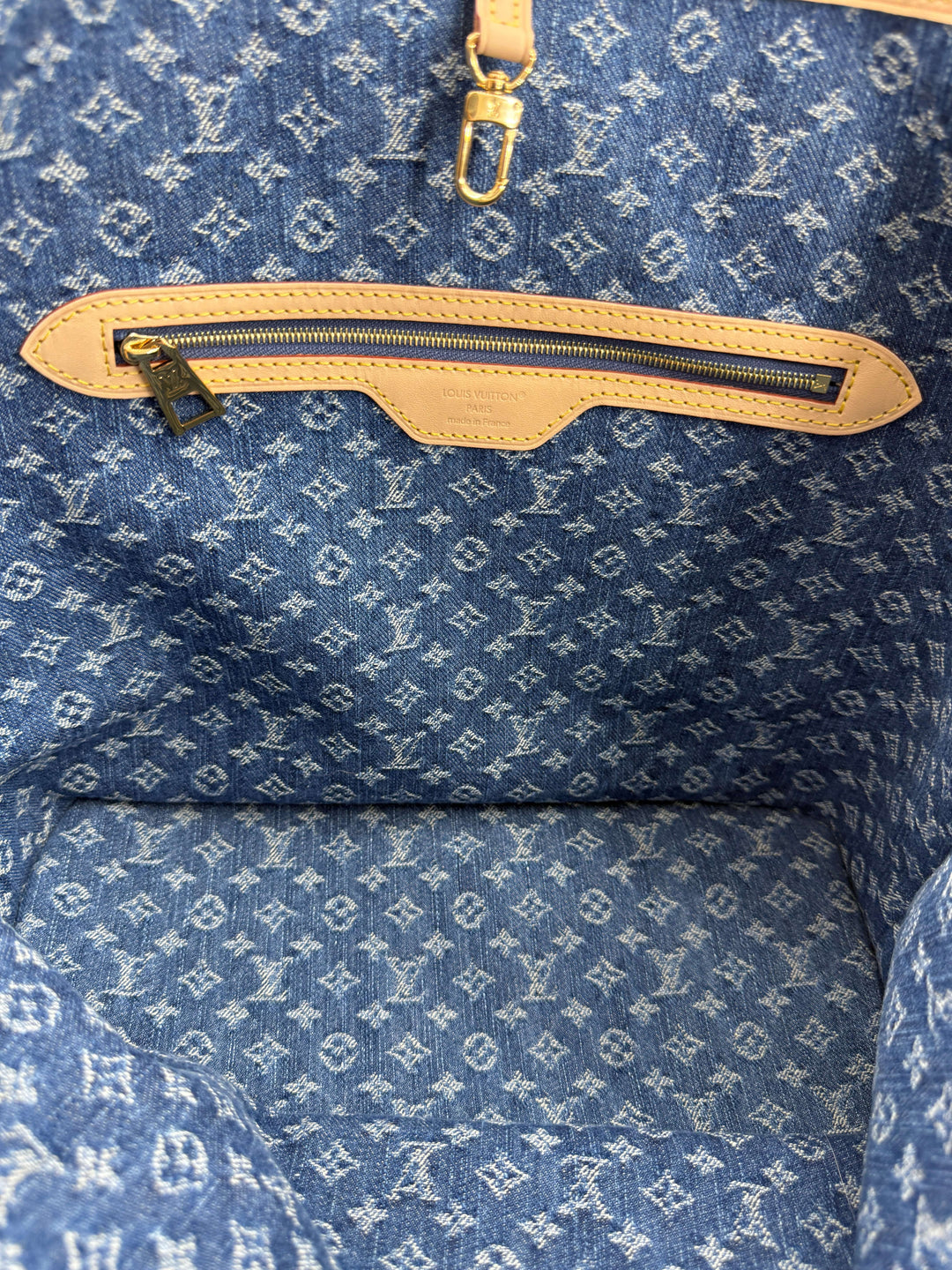 Interior view of the Louis Vuitton Neverfull MM Monogram Denim | LuxLoveLouis showcasing denim fabric and zip pocket.