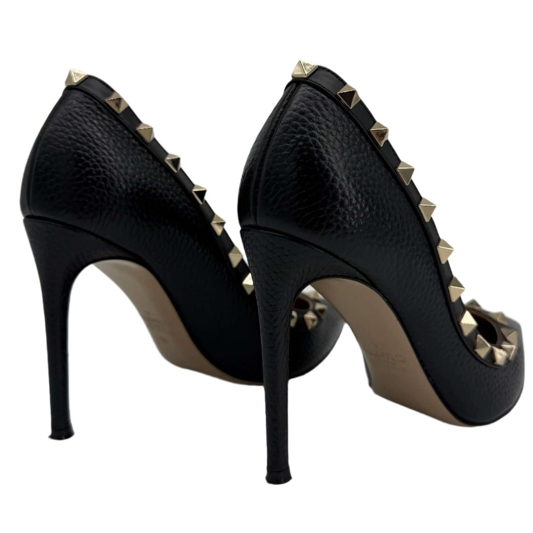 Valentino Garavani black pebbled leather Rockstud pumps with gold-tone studs, showcasing elegant stiletto heel design.