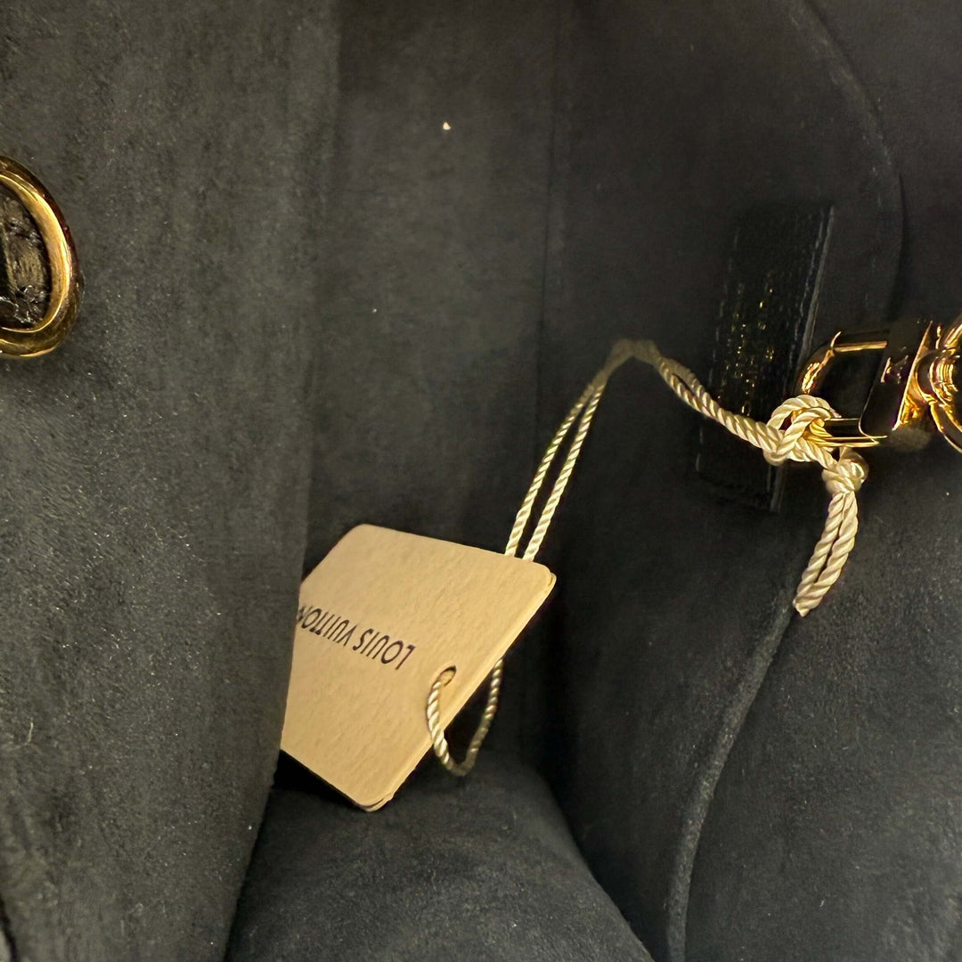 Interior view of the Louis Vuitton OnTheGo BB Monogram Empreinte Black | LuxLoveLouis showing the tag and detailing.