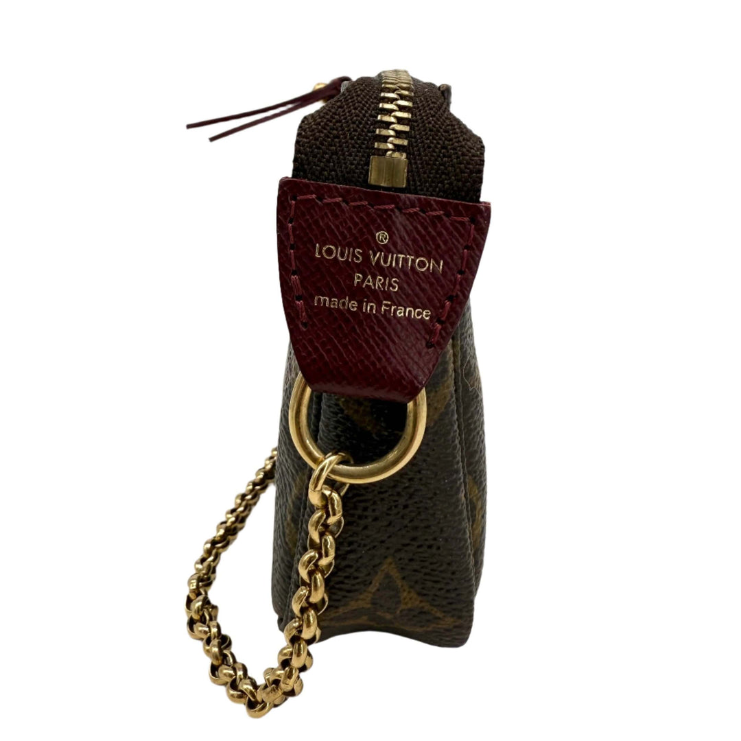 Side view of Louis Vuitton Monogram Stamp Mini Pochette showing logo and gold chain detail, crafted in classic coated canvas.