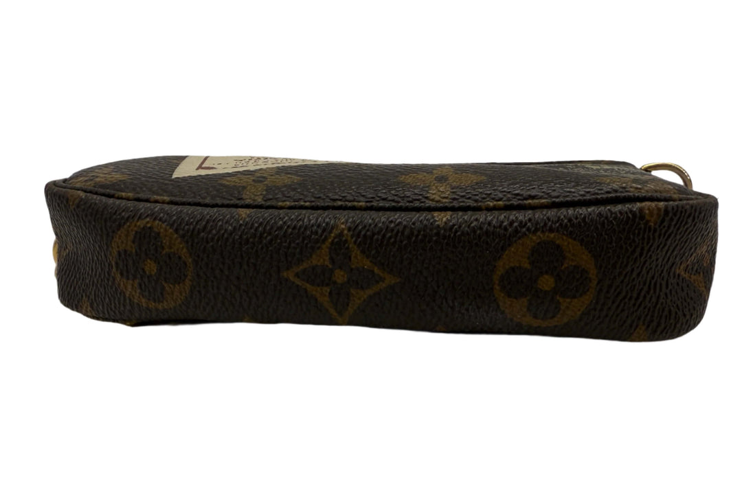 Louis Vuitton Monogram Stamp Mini Pochette Accessories side view showcasing classic coated canvas design.