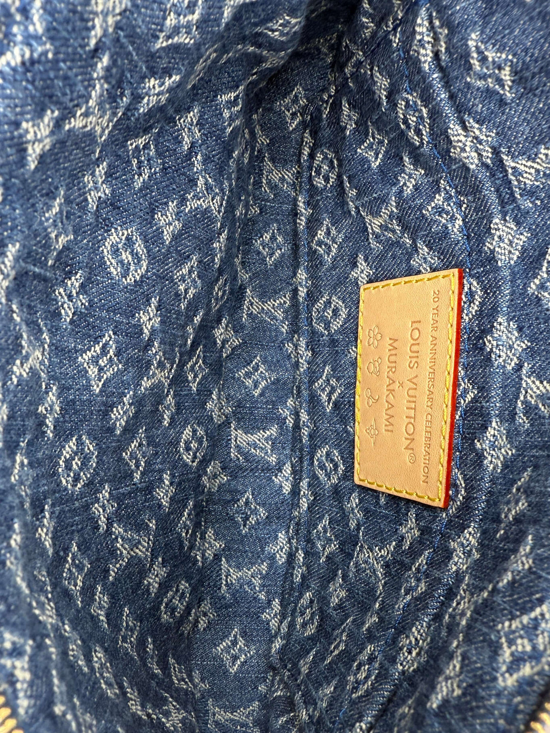 Interior view of the Authentic Louis Vuitton x Murakami Pochette Accessoires in Monogram Cherry Denim with brand tag.