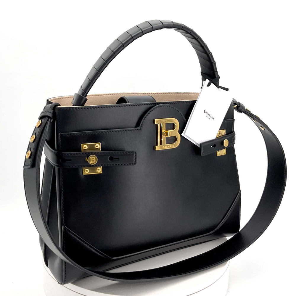 BALMAIN B-Buzz 31 Calfskin Top-Handle Bag in Black|LuxLoveLouis | Step into the world of refined elegance with the Balmain BBuzz 31 Calfskin Top-Handle Bag in Black. Crafted from premium calfskin, this sleek, black bag features luxurious finishes, perfect
