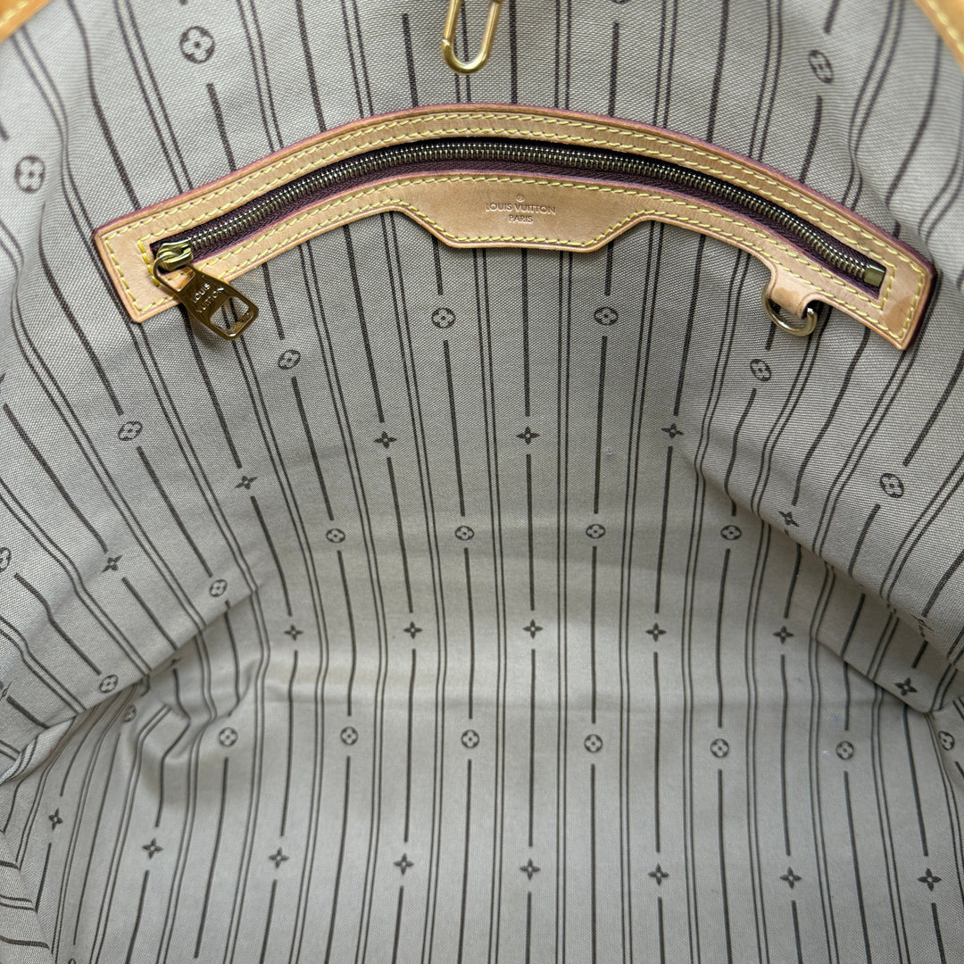 Interior view of Louis Vuitton Monogram Delightful MM hobo bag, featuring striped lining and zip pocket.