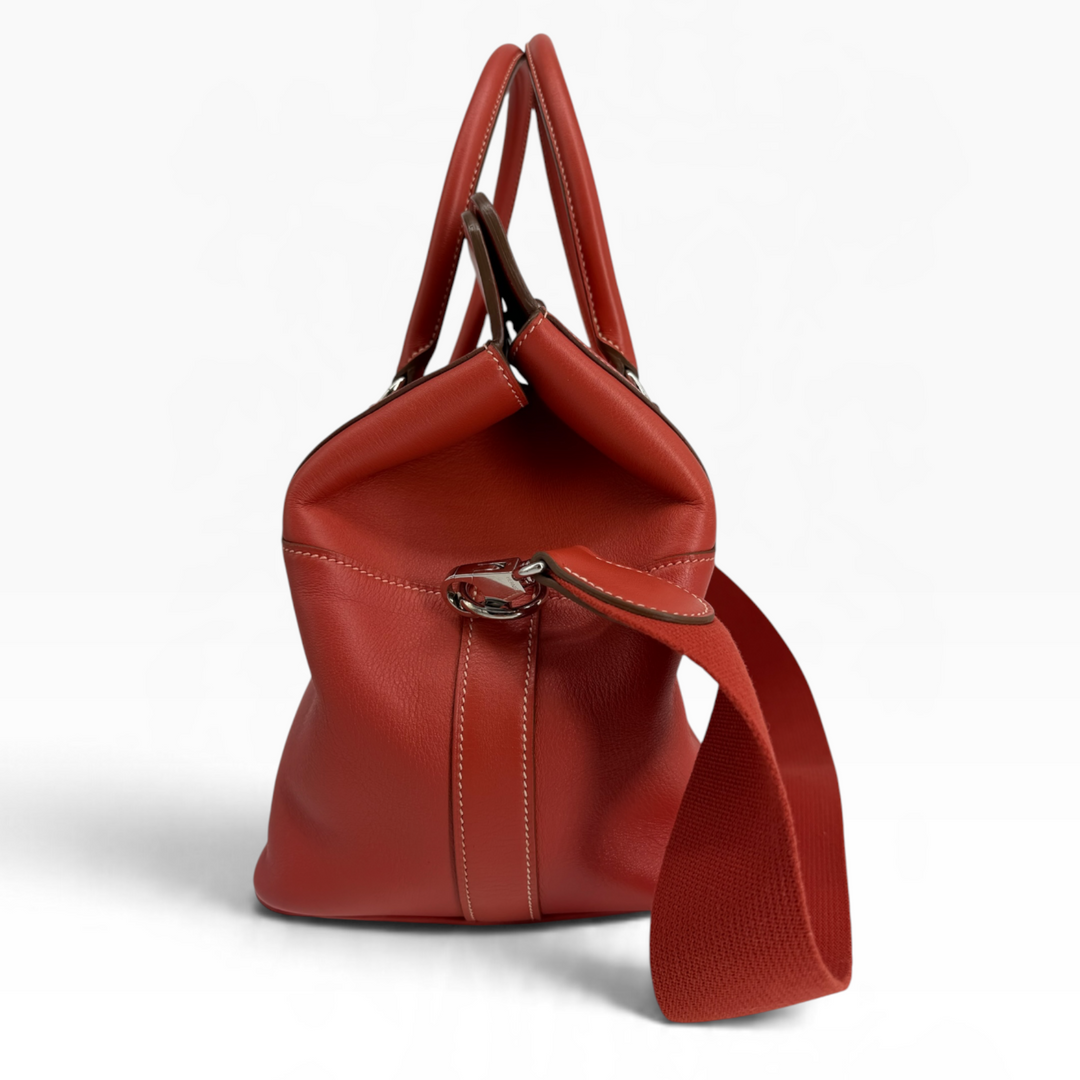 Hermès Toolbox 26 Capucine Swift leather side profile showing expandable gusset and detachable textile strap