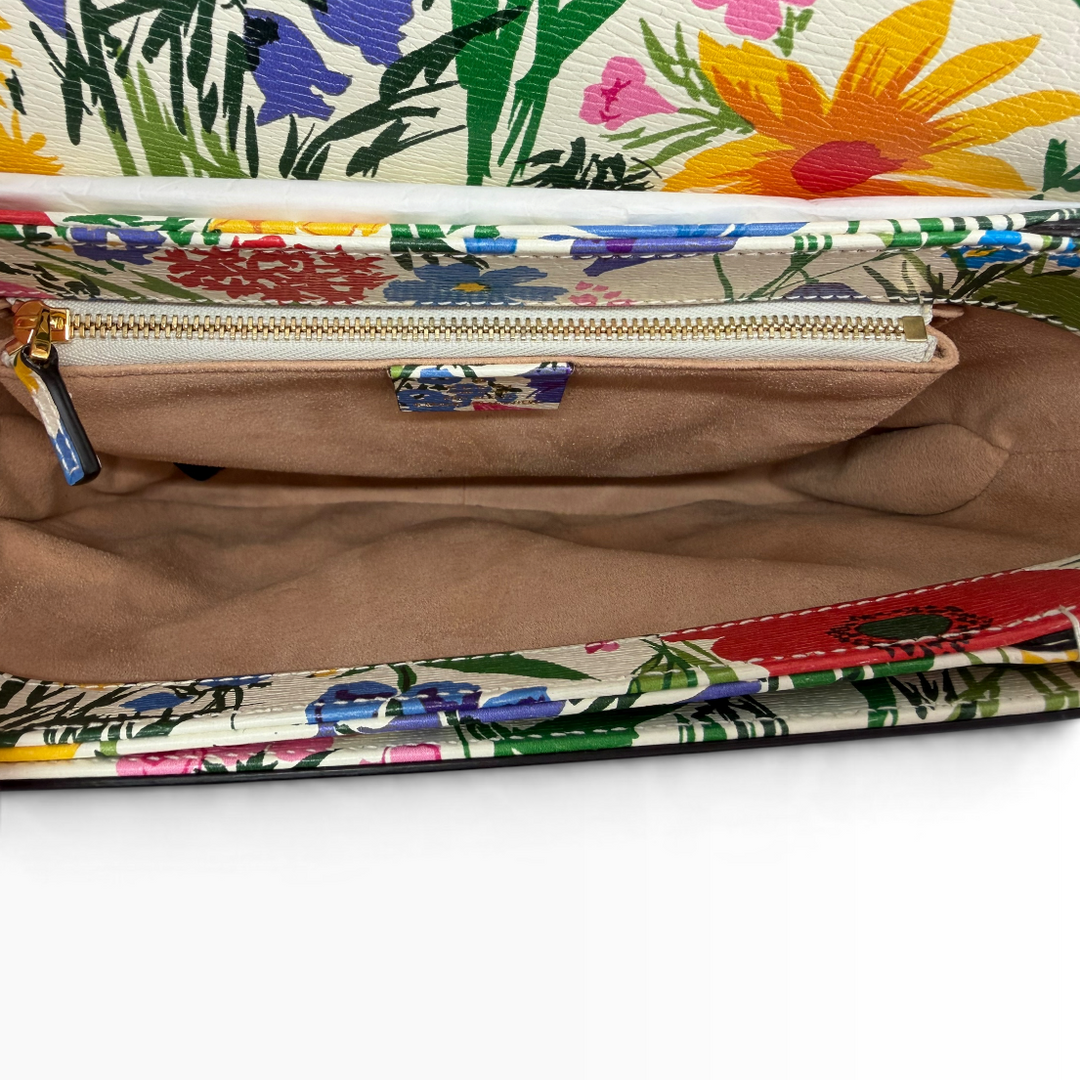 Interior of Gucci x Ken Scott Horsebit 1955 Medium shoulder bag showing beige suede-like lining, gold-tone zipper and floral-trimmed pocket