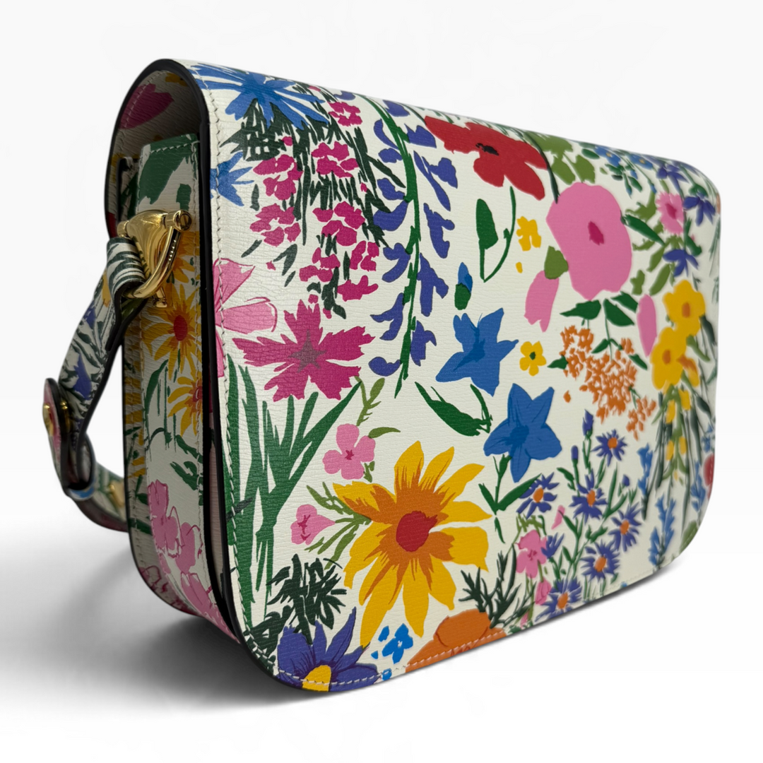 Interior of Gucci x Ken Scott Horsebit 1955 Medium shoulder bag showing beige suede-like lining, gold-tone zipper and floral-trimmed pocket