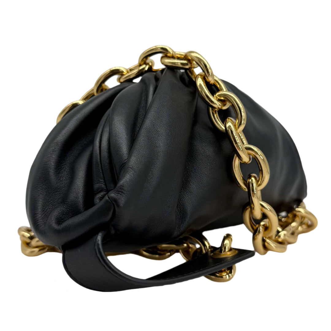 Bottega Veneta The Pouch Chain handbag in black calfskin leather with gold chain strap, showcasing its modern design.