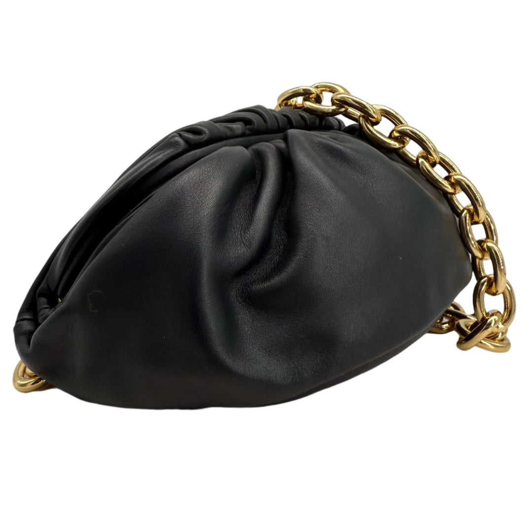 Bottega Veneta The Pouch Chain bag in black calfskin leather with gold chain strap, showcasing its sculptural design.