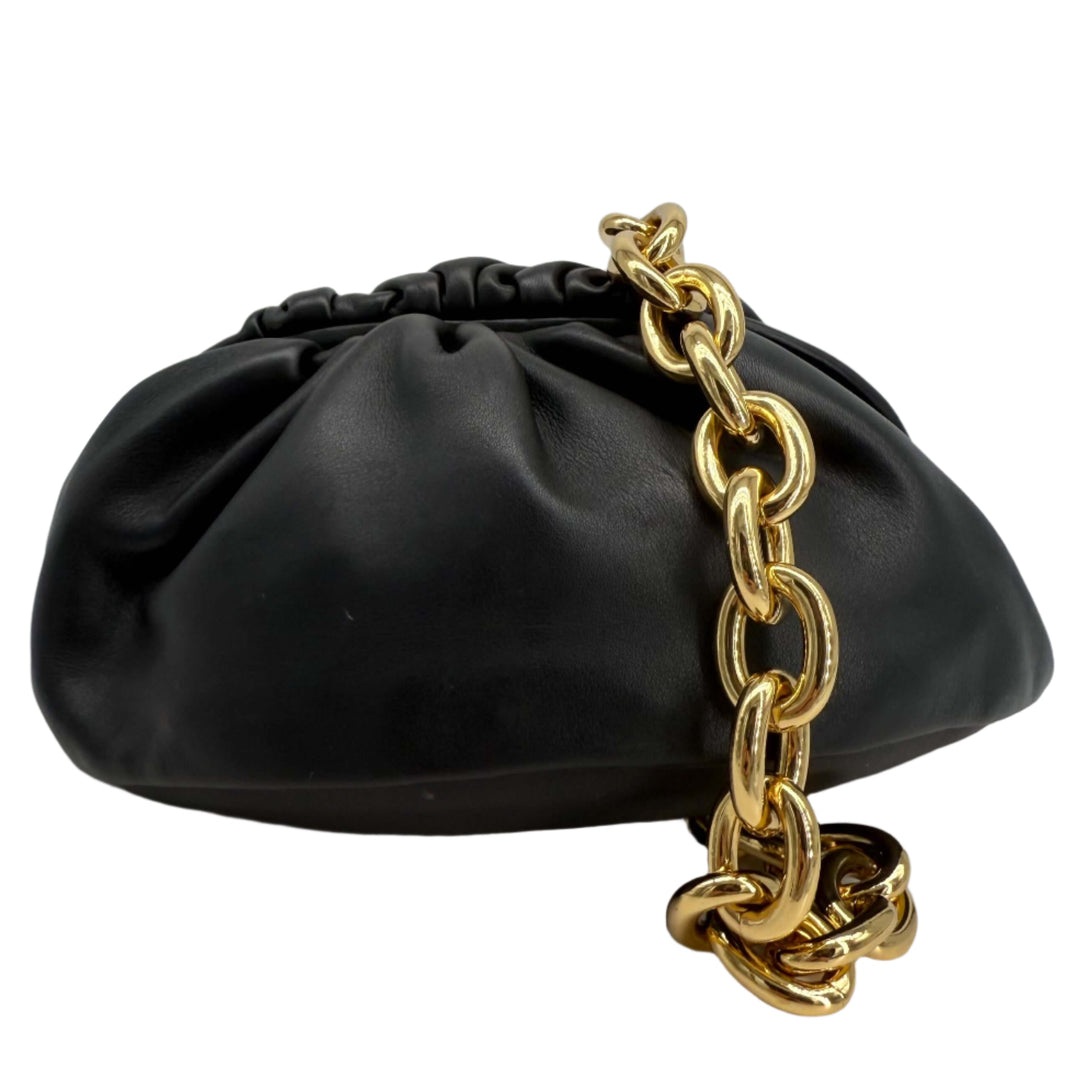 Bottega Veneta The Pouch Chain in black calfskin leather with a gold chain strap, featuring a sculptural design.