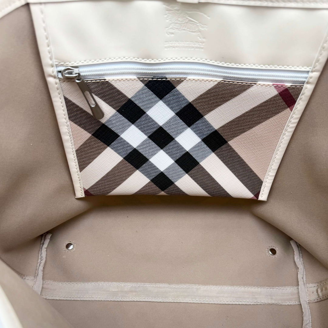 Interior view of Burberry Nova Check Large Nickie Tote featuring a check pattern zip pocket and beige lining.