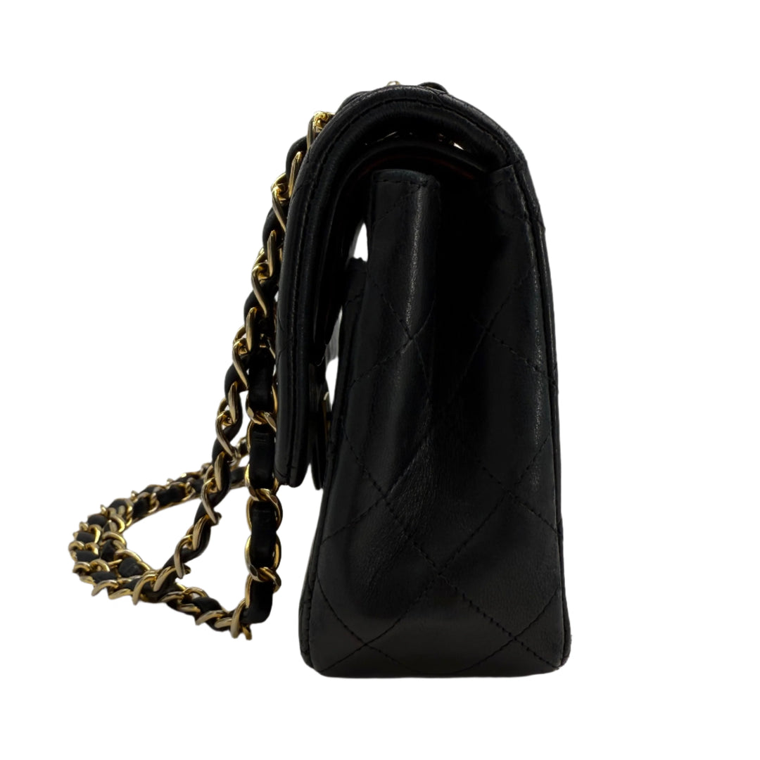 Side view of CHANEL Lambskin Quilted Small Double Flap Bag in black with gold hardware and chain-link strap.