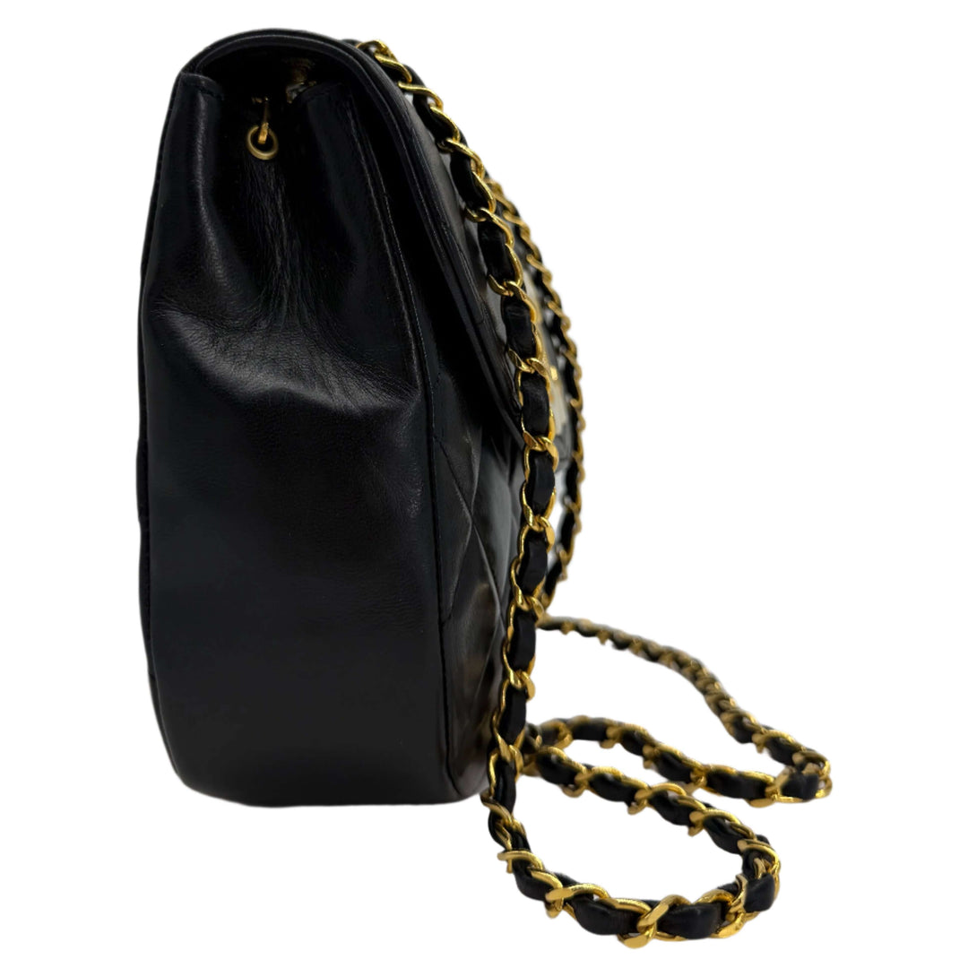 Chanel Lambskin Quilted Small Single Flap Bag side view, showcasing its gold chain and elegant black leather.